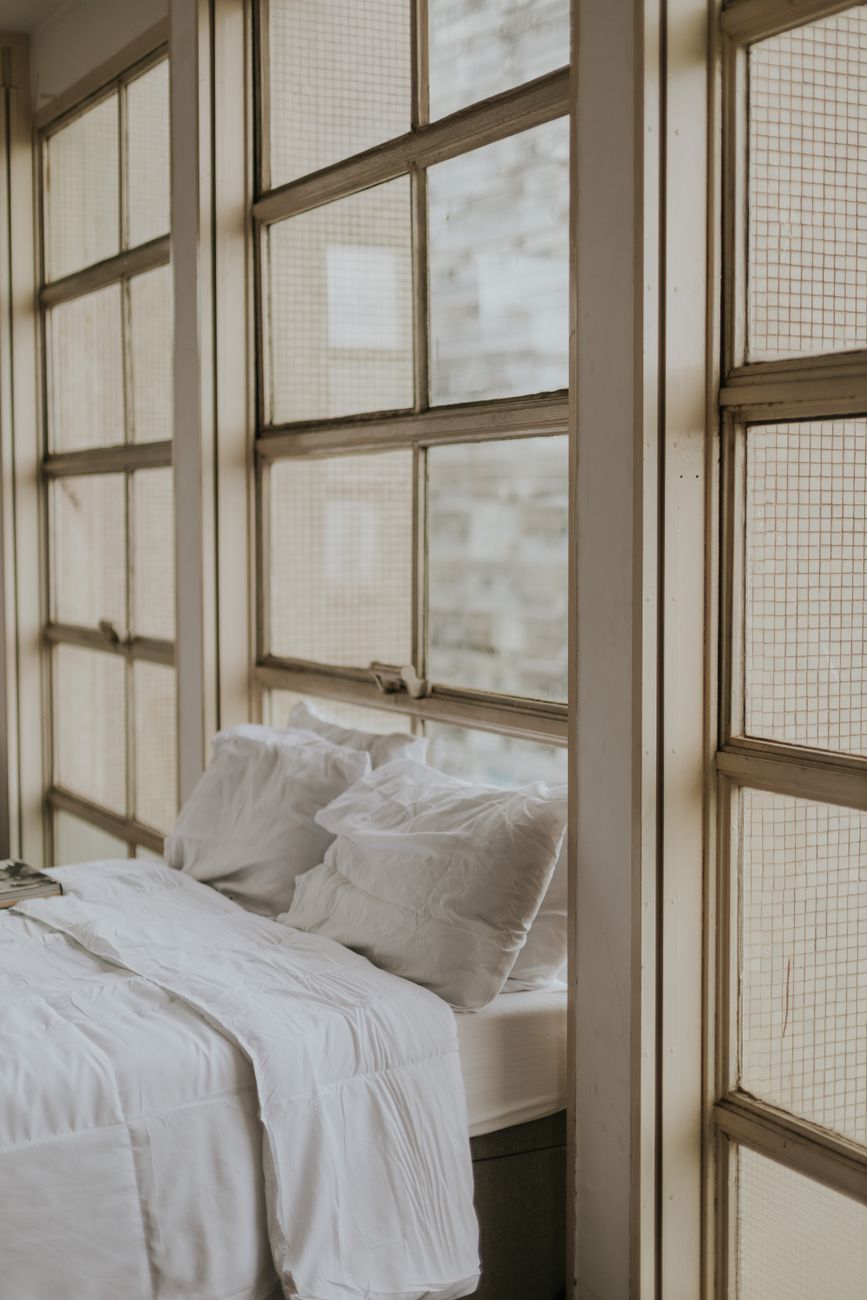 cozy minimalist bedroom with large windows