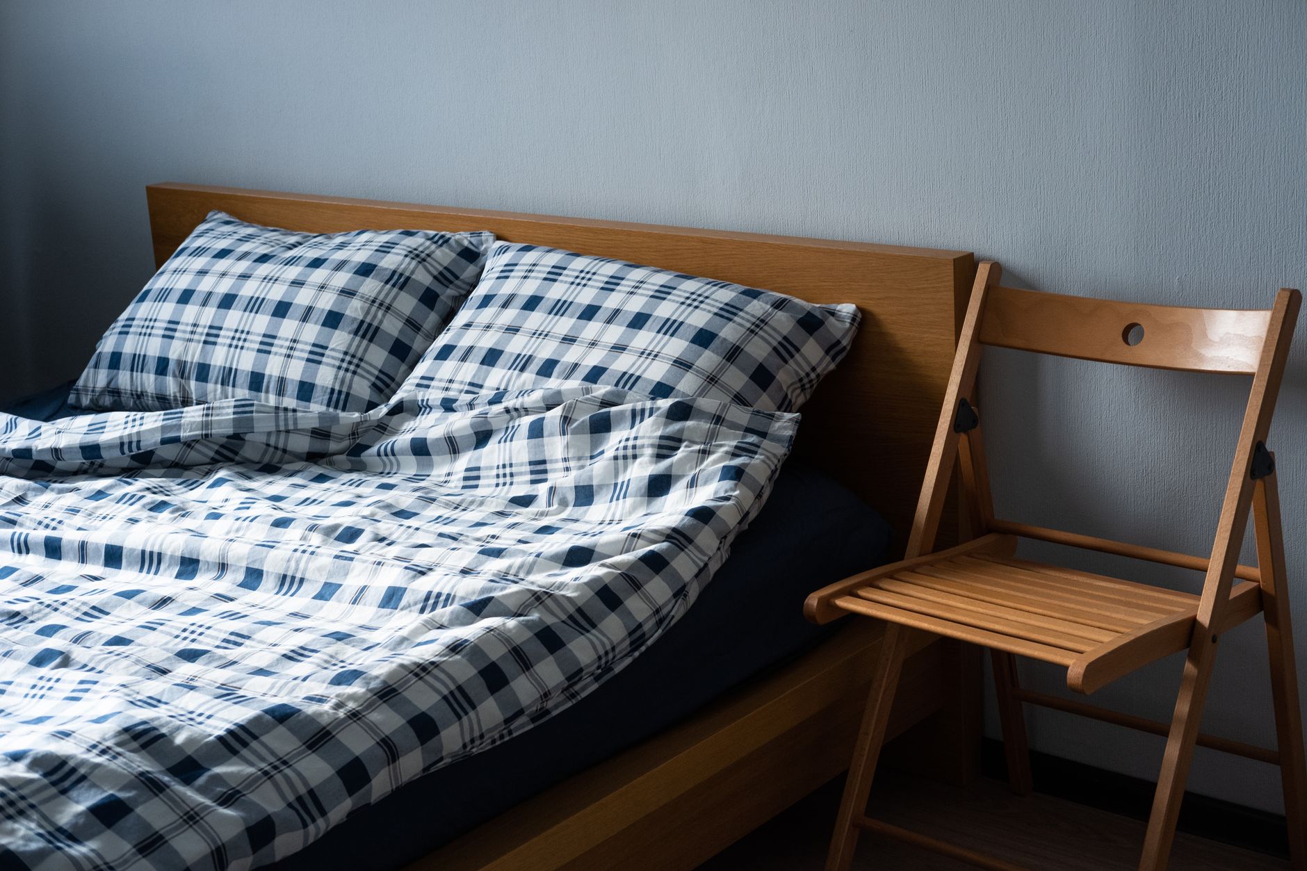 wooden bed with checkered linen