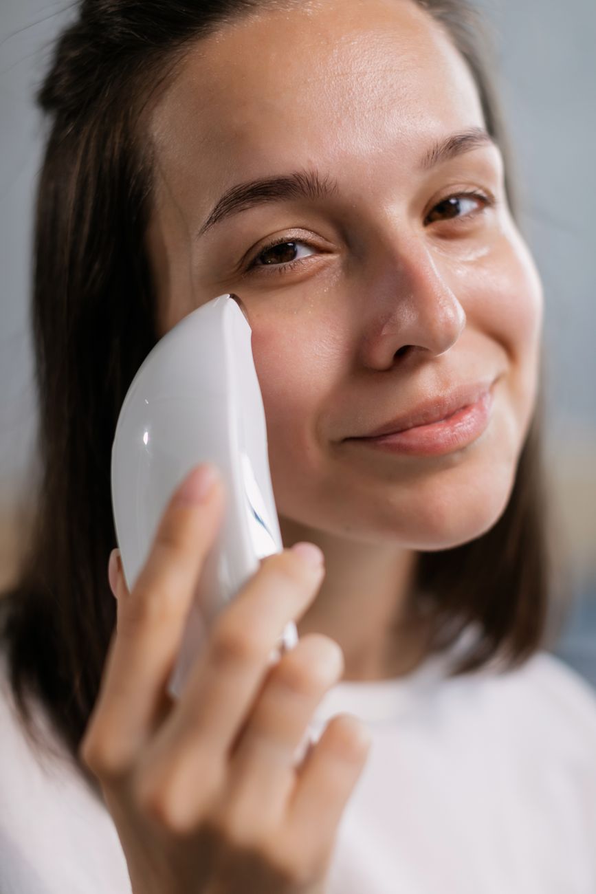 close up of a woman holding a facial brush