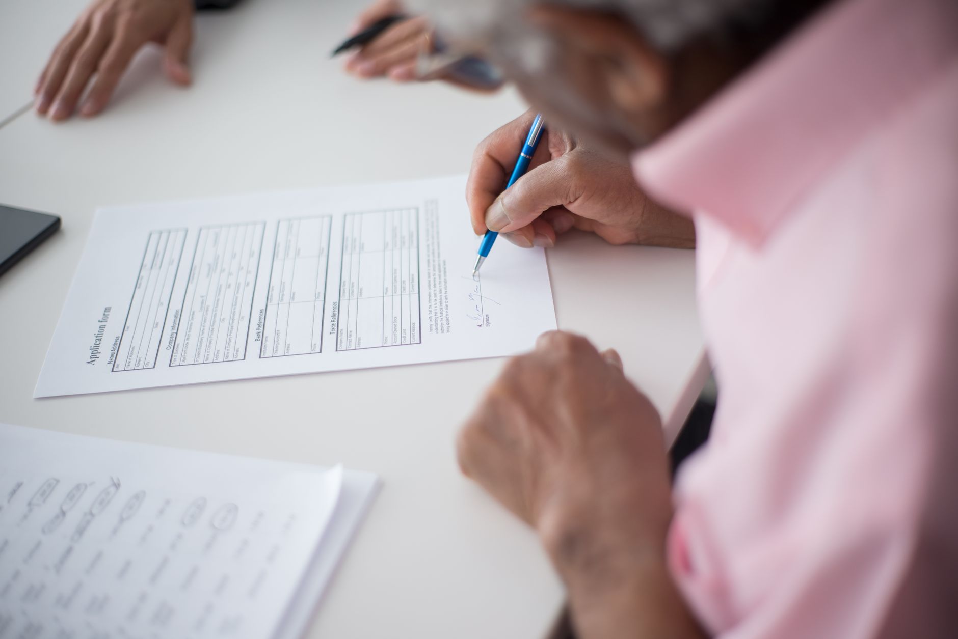 elderly man signing an application form